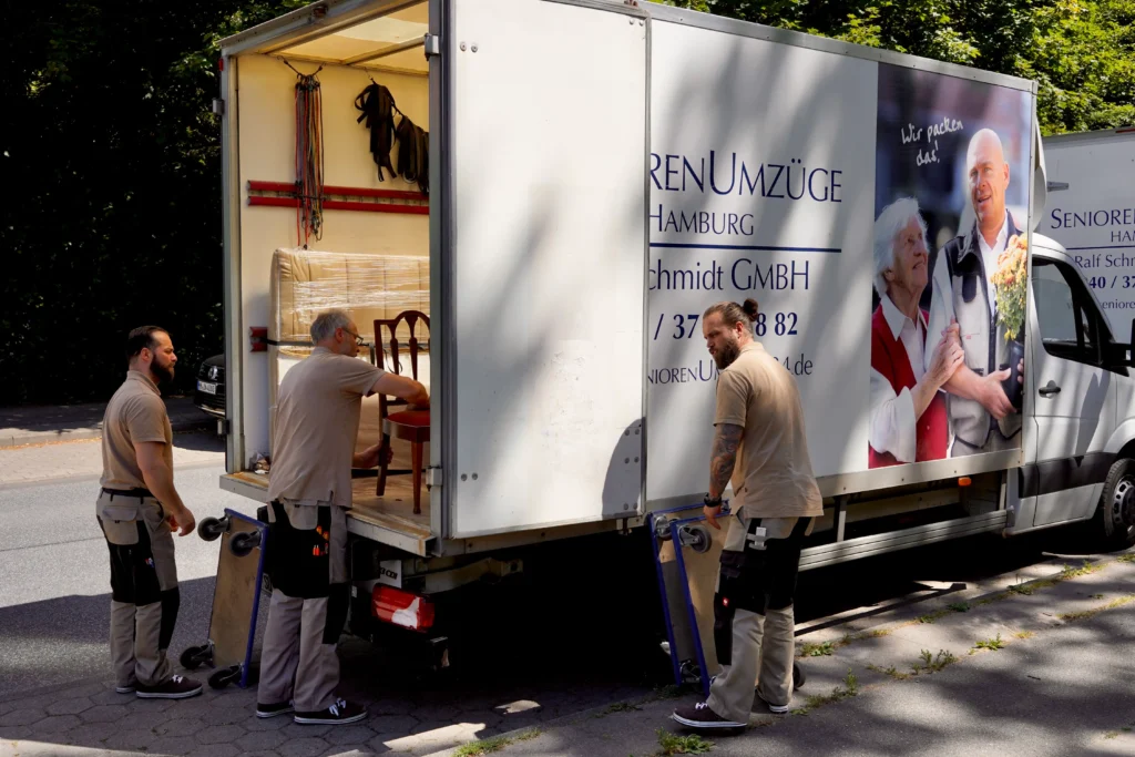 Umzugshelfer laden Möbel aus einem LKW.