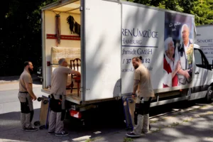 Umzugshelfer laden Möbel aus einem LKW.